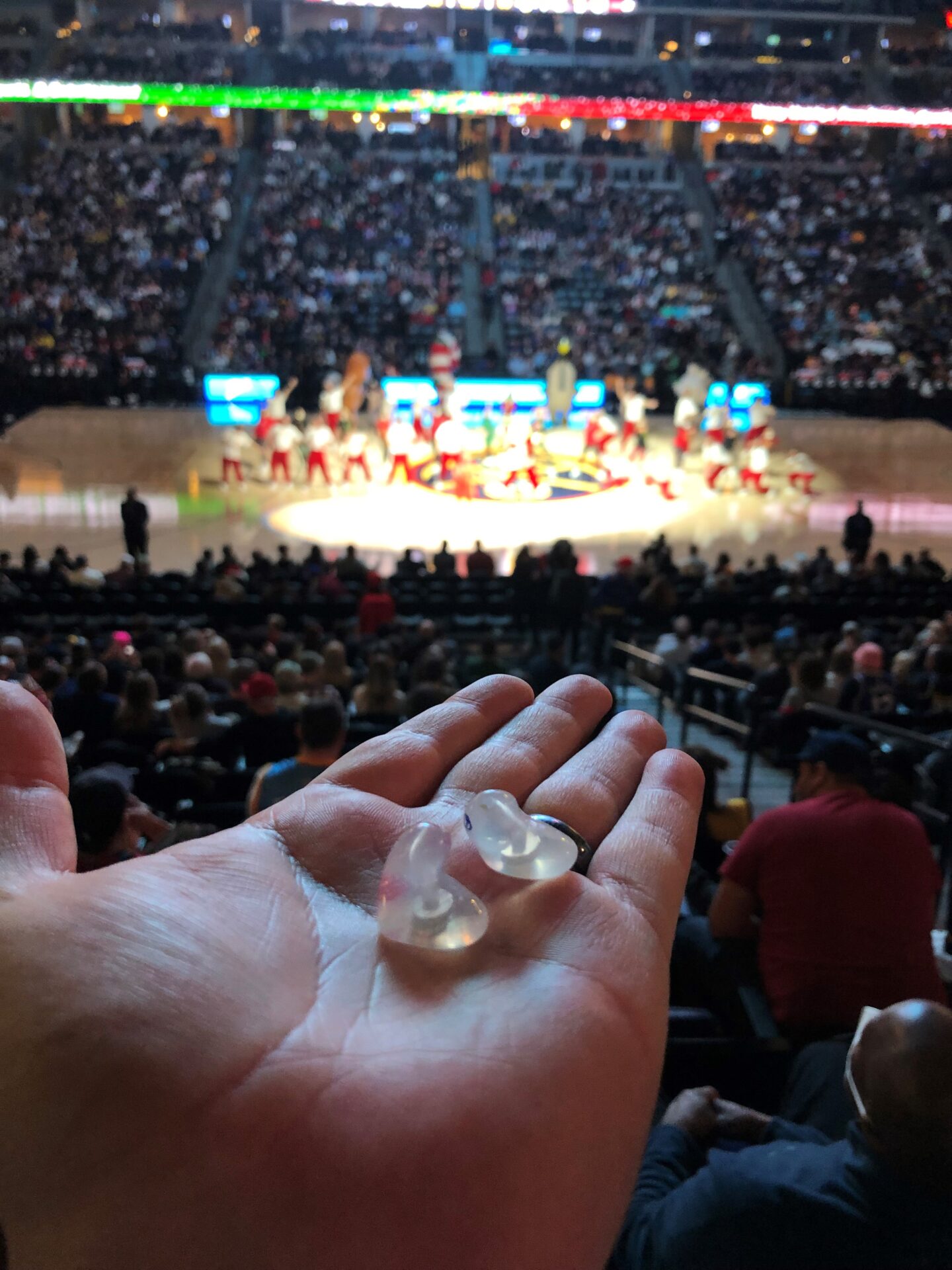 A heart-shaped stone on the palm of a person watching an event on a stadium