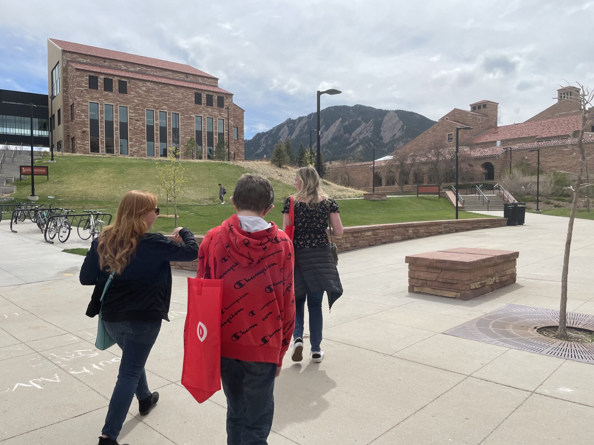 Two woman and a boy walking on campus