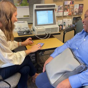 Two people smiling in an office setting.