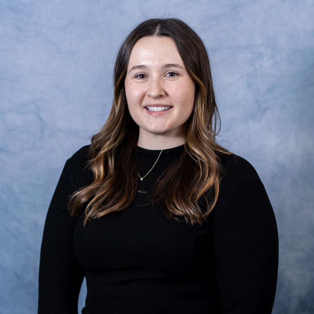 Smiling woman in a black top.