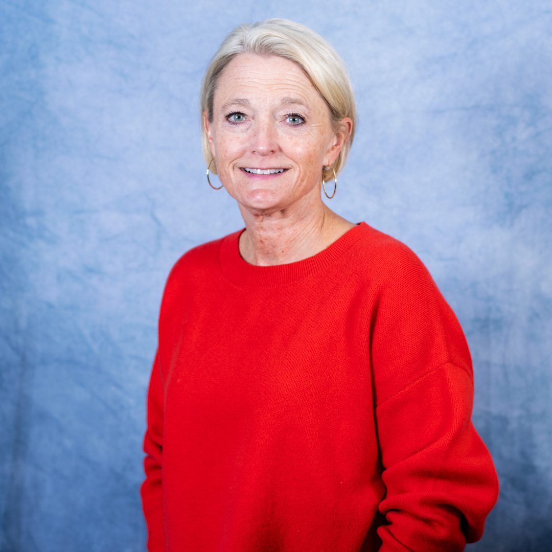 Woman in red sweater, blue background.