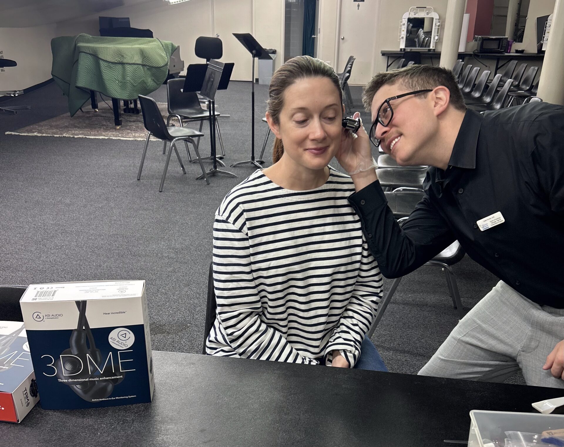 Person examining woman's ear with otoscope.