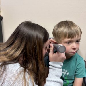 Child's ear being examined by a woman.