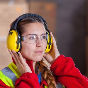 Woman wearing safety gear in warehouse.