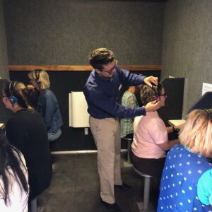 Hearing test booths with people and examiner.